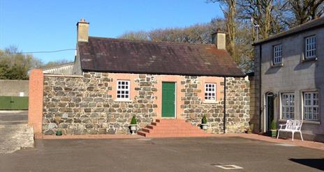 outside image of the Apple house with green door and stone walls