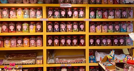 Shelves filled with jars of dozens of different home made sweets.