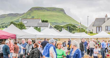 People browsing busy outdoor market stalls