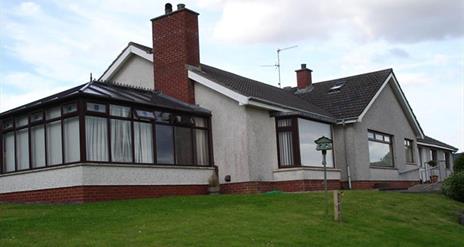 Image shows outside view of the property with sun room