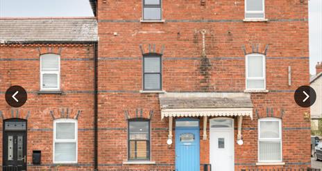 Front of house showing blue front door and all 3 storeys