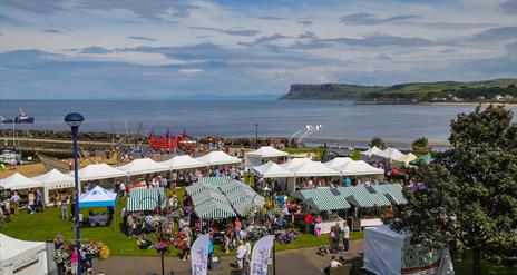 crowds of people browsing busy seaside market stalls