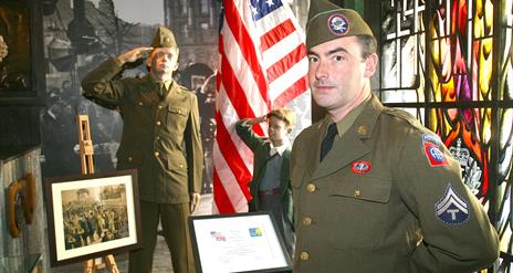 A man dressed up in a uniform from the Second World War standing in the gallery of the Northern Ireland War Memorial.