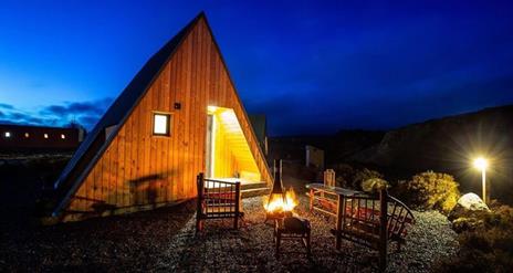 firepit and 2 chairs outside glamping pod