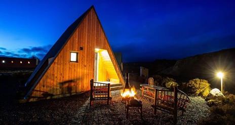 firepit and 2 chairs outside glamping pod