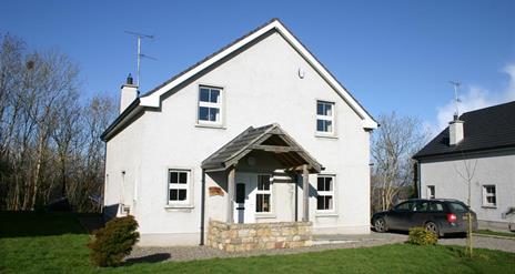 Large white two store house with stone porch feature