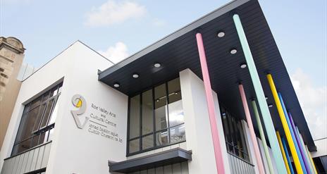 Photo of the front of the building. Windows and white walls with large 'R' logo and text reading "Roe Valley Arts and Cultural Centre". There are also