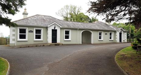 Image shows front of property with gravel driveway