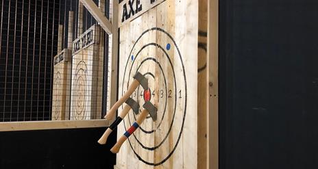 Axes stuck in a wooden target board.