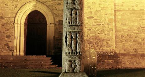 High Cross lit up at night outside Down Cathedral, Downpatrick