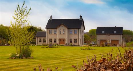 Outside view of 2 storey house with double garage and large garden