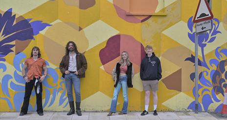 Banshee the overall winners from Buskfest 2024 pictured against street art in Banbridge.