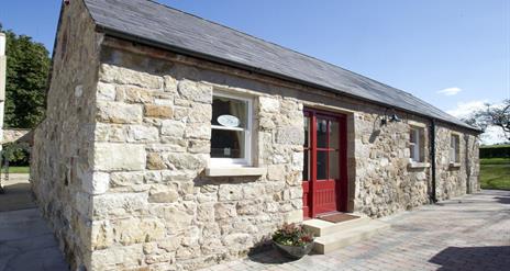 entrance to cottage with red door and stone walls