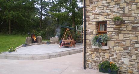 Outside patio area with firepit and wooden chair