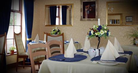 Image shows breakfast room with tables and chairs