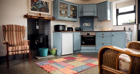 Kitchen area with stove and fireside seating