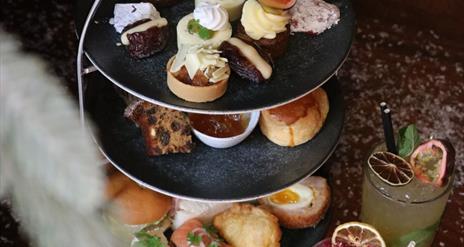 3 tier afternoon tea stand with savoury and sweet treats with cocktails & mocktails