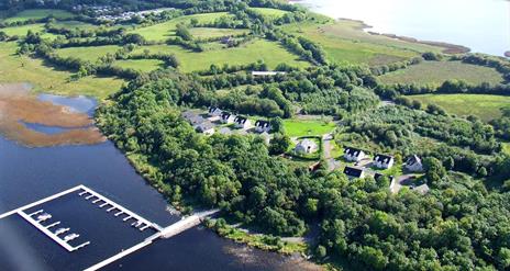 Aerial site photograph of green site with marina in lake