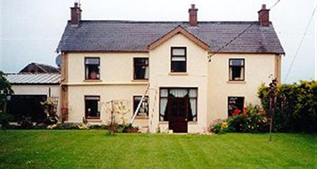 A large two-story lodge with a lawn.