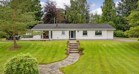 Photograph of front of house and green lawn