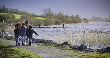 Family walking along the shores of lough Fea.