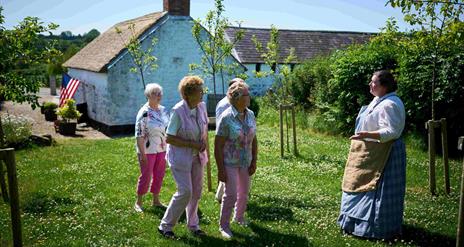 Group of people walking through garden at Arthur Cottage