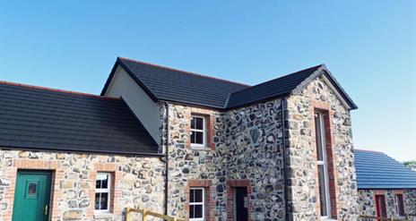 Front exterior view of stone cottages.