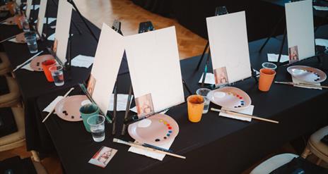 Photo of canvases, paint palettes and glasses of prosecco in the Ulster Museum