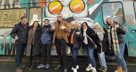 Group shot outside of pyke n pommes double decker bus restaurant