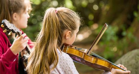 Homegrown Harmonies, two girls playing instruments. A Celebration of Traditional Music & Culture
