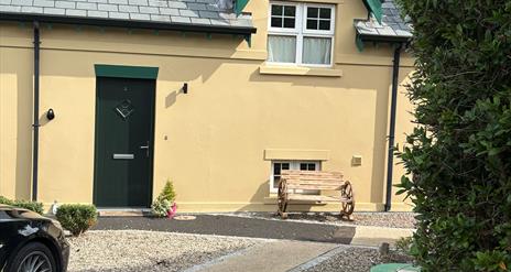 Photograph of front of The Distillers View, bench and plant