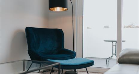 Lounge chair and lamp beside patio window