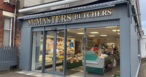 Grey shop frontage of McMasters Butchers in Whitehead