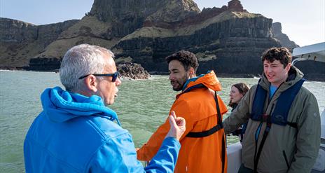 Guide/skipper of the boat talking to a group enjoying the Giant Shipwrecks of the North Coast experience