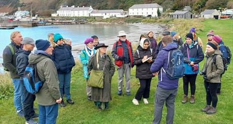 people gather outside on Rathlin Island listening to a tour guide