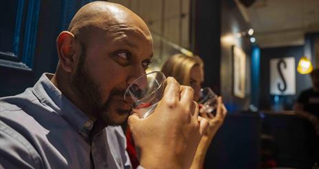 Guests taste mystery liquids during the Sensorium experience