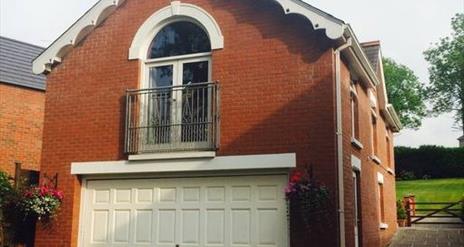 Image shows upstairs apartment patio doors and garage underneath