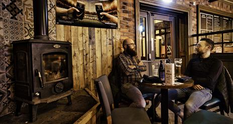 Two males chatting over a drink at The Bridge Bar