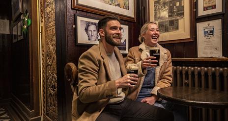 2 people enjoying a Guinness in Blakes of the Hollow