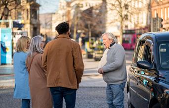 Billy Scott greets his tour group for the Belfast Black Cab Tour