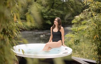 Private riverside hot tub in an autumnal setting at Galgorm