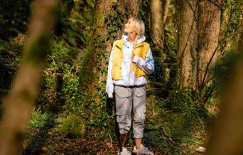 Girl standing pensively beside a tree as part of the Mussenden Unwind experience