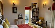 Bedroom with double bed. Bookcase beside exterior door which opens out onto decking.