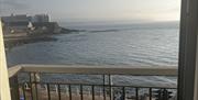 Image of doors open onto juliette balcony with sea view and onto Portstewart Promenade with vehicle