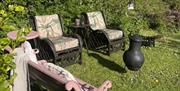 the secret garden with comfy chairs of the pink cottage