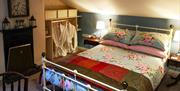 A double bedroom with a fireplace and two bath robes.