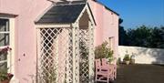 Outside view of the pink cottage with trellis porch