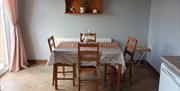 A kitchen area with a table and chairs and a patio door.