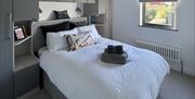 Double bedroom with a window and a large wardrobe surrounding the bed.