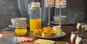 Breakfast displayed psalteries, cold sliced meats, sliced cheese, yoghurts and fresh orange juice.